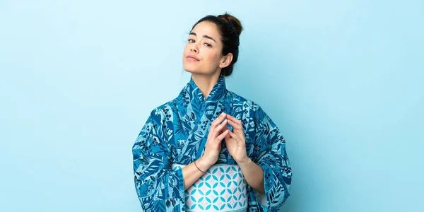 Woman wearing kimono over isolated background scheming something