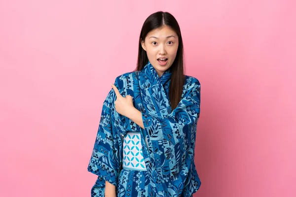 Joven Chica China Usando Kimono Sobre Fondo Aislado Sorprendido Apuntando —  Fotos de Stock