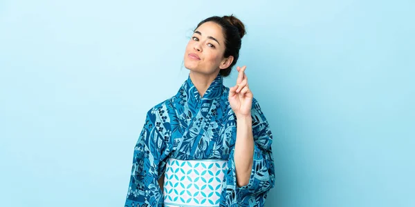 Frau Trägt Kimono Über Isoliertem Hintergrund Mit Daumendrücken Und Wünscht — Stockfoto
