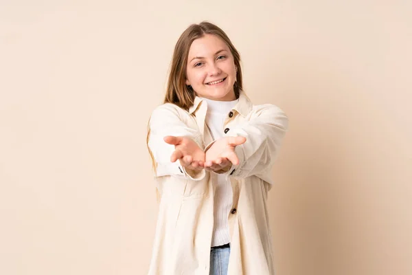 Teenager Ukrainian Girl Isolated Beige Background Holding Copyspace Imaginary Palm — Stock Photo, Image