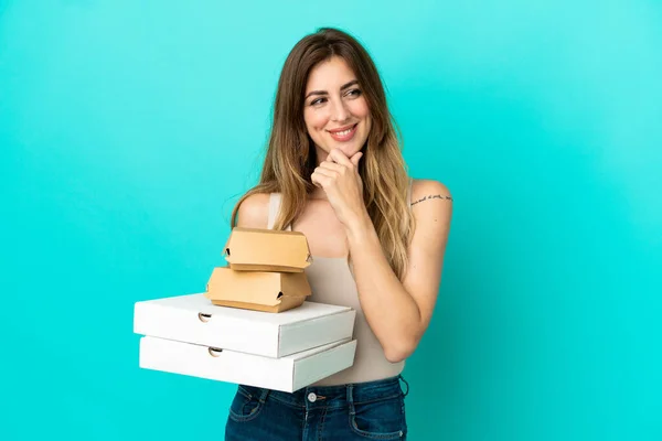 Femme Caucasienne Tenant Des Pizzas Hamburger Isolé Sur Fond Bleu — Photo