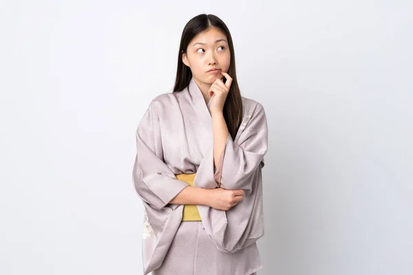 Joven Chica China Usando Kimono Sobre Fondo Aislado Teniendo Dudas —  Fotos de Stock