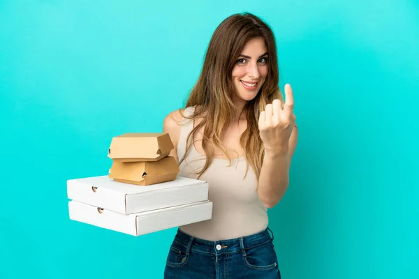 Kaukasische Frau Hält Pizzen Und Burger Isoliert Auf Blauem Hintergrund — Stockfoto