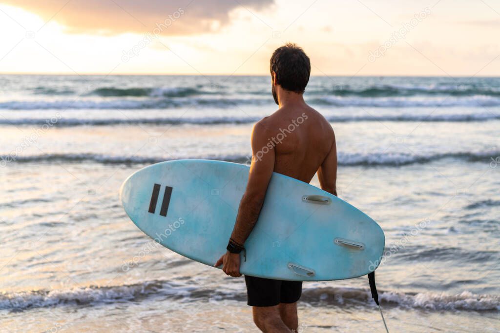 Young caucasian man get up early to  doing surf at sunrise