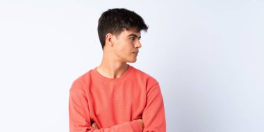 Yakışıklı bir adam mavi arka planda, yana bakıyor.