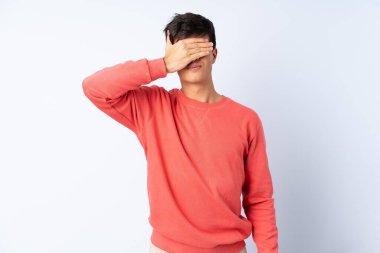 İzole edilmiş mavi arka planda yakışıklı bir adam. Gözlerini elleriyle kapatıyor. Bir şey görmek istemiyorum.
