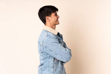 İzole edilmiş bej arka planda yakışıklı bir adam.