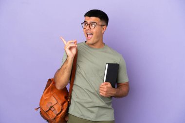 Tecrit edilmiş arka planda yakışıklı bir öğrenci parmak kaldırırken çözümü bulmayı amaçlıyor.