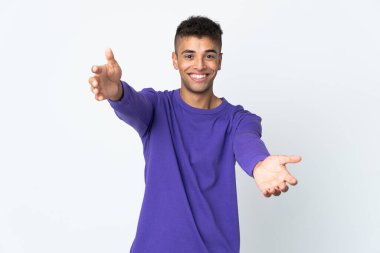 Beyaz arka planda izole edilmiş genç Brezilyalı adam sunar ve davet eder.