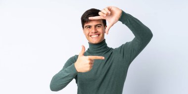 İzole edilmiş mavi arka plan odaklı yakışıklı bir adam. Çerçeve sembolü