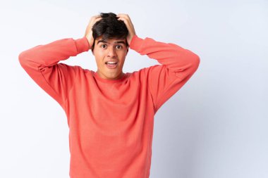 Yakışıklı bir adam soyutlanmış mavi arka planda gergin hareketler yapıyor.