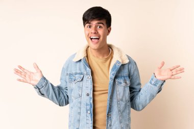 Yüzünde şok ifadesi olan, izole edilmiş bej bir geçmişi olan yakışıklı bir adam.