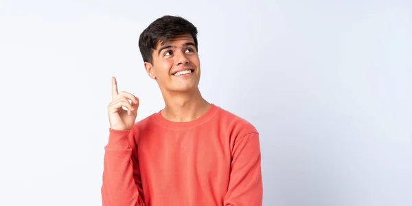 Hombre Guapo Sobre Fondo Azul Aislado Apuntando Una Gran Idea —  Fotos de Stock