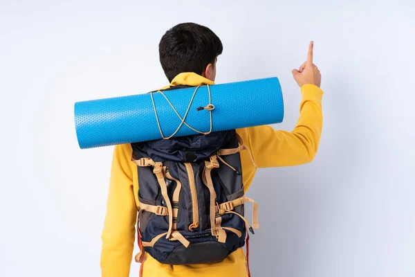 Joven Montañero Con Una Gran Mochila Sobre Fondo Azul Aislado —  Fotos de Stock