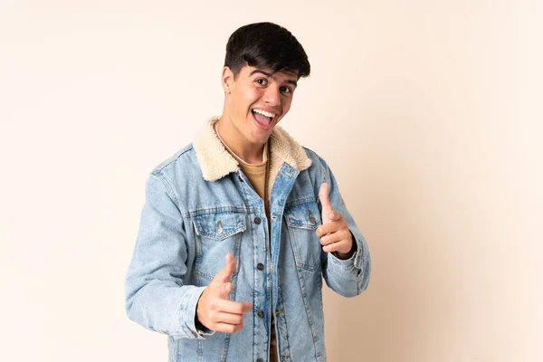 Bonito Homem Sobre Fundo Bege Isolado Apontando Para Frente Sorrindo — Fotografia de Stock