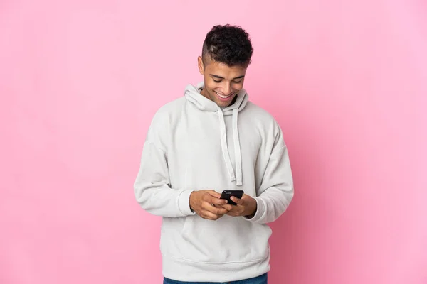Pembe Arka Planda Izole Edilmiş Genç Brezilyalı Adam Cep Telefonuyla — Stok fotoğraf