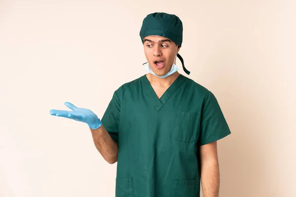 Surgeon Man Blue Uniform Isolated Background Holding Copyspace Imaginary Palm — Stock Photo, Image