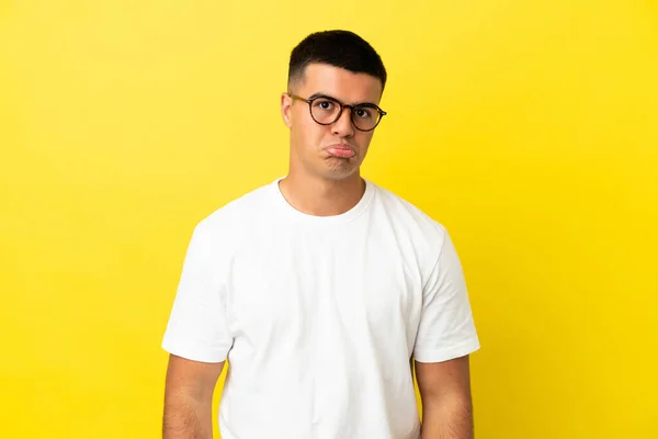 Junger Gutaussehender Mann Mit Traurigem Gesichtsausdruck Vor Isoliertem Gelben Hintergrund — Stockfoto
