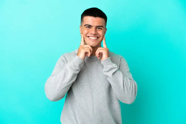 Mladý Pohledný Muž Přes Izolované Modré Pozadí Úsměvem Šťastný Příjemný — Stock fotografie