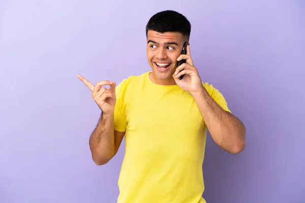 Joven Hombre Guapo Utilizando Teléfono Móvil Sobre Fondo Púrpura Aislado —  Fotos de Stock