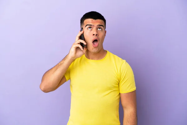 Joven Hombre Guapo Usando Teléfono Móvil Sobre Fondo Púrpura Aislado —  Fotos de Stock