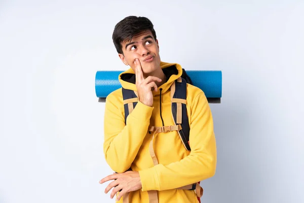 Joven Montañero Con Una Gran Mochila Sobre Fondo Azul Aislado — Foto de Stock