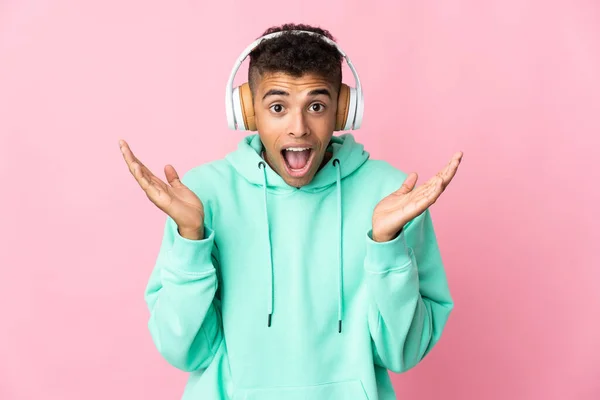 Pembe Arka Planda Izole Genç Brezilyalı Adam Şaşırdı Müzik Dinliyor — Stok fotoğraf