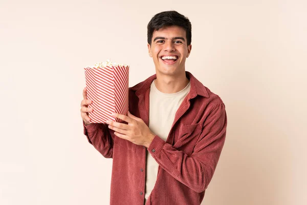 Pohledný Muž Nad Izolovaným Pozadím Drží Velký Kýbl Popcornů — Stock fotografie