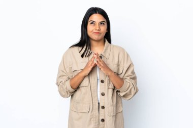 Beyaz arka planda izole edilmiş genç Latin kadın bir şeyler planlıyor.