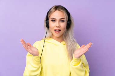 Mor arka planı olan genç bir kız şaşırdı ve müzik dinliyor.