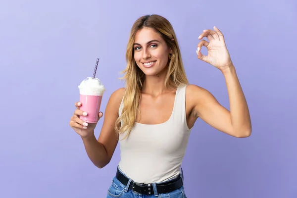 Молодая Блондинка Уругвая Клубничным Молочным Коктейлем Изолированы Фиолетовом Фоне Показывая — стоковое фото