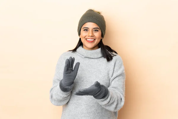 Ung Colombiansk Flicka Med Vinter Hatt Isolerad Beige Bakgrund Applåderar — Stockfoto