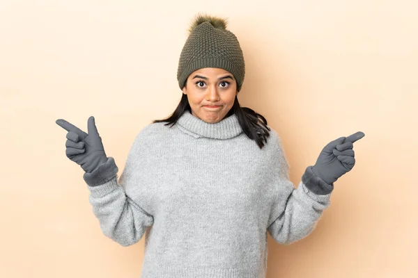 Jovem Colombiana Com Chapéu Inverno Isolado Fundo Bege Apontando Para — Fotografia de Stock