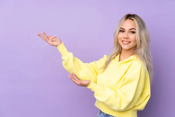 Tenåringsjente Med Gul Genser Isolert Lilla Bakgrunn Strekker Hender Til – stockfoto