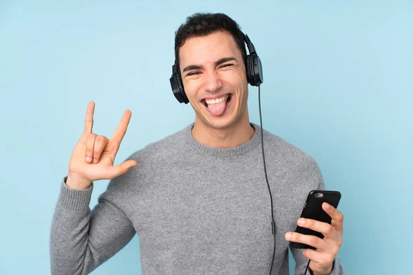 Jonge Blanke Knappe Man Geïsoleerd Blauwe Achtergrond Luisteren Muziek Met — Stockfoto