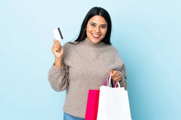 Ung Latinamerikansk Kvinna Isolerad Blå Bakgrund Håller Shoppingväskor Och Ett — Stockfoto