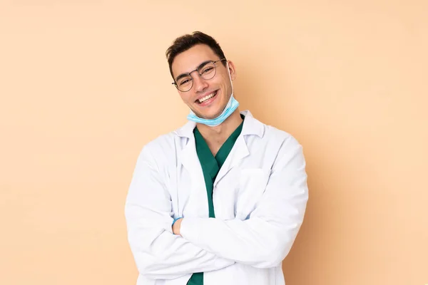 Młody Dentysta Trzyma Narzędzia Odizolowane Beżowym Tle Okularami Uśmiechem — Zdjęcie stockowe
