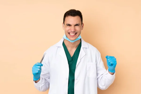 Jovem Dentista Homem Segurando Ferramentas Isoladas Fundo Bege Celebrando Uma — Fotografia de Stock