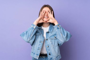 Mor arka planda izole edilmiş genç beyaz kız bağırıyor ve bir şeyler söylüyor.