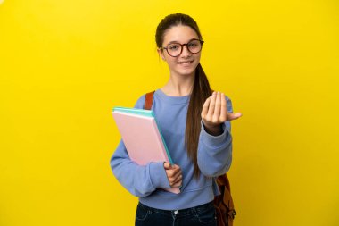 İzole edilmiş sarı arka planda öğrenci bir kadın. Bizimle gelmesi için davet ediliyor. Gelmene sevindim.