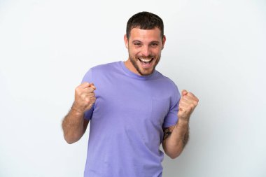 Genç Brezilyalı adam beyaz arka planda tek başına zaferi kutluyor.