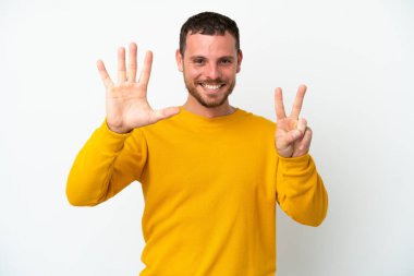 Beyaz arka planda izole edilmiş genç Brezilyalı adam yediyi parmaklarıyla sayıyor