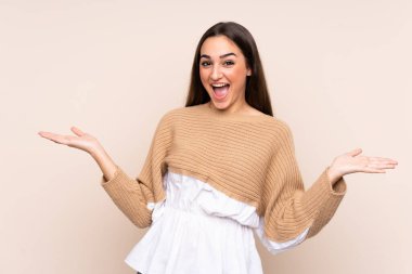 Yüzünde şok ifadesi olan bej bir arka planda izole edilmiş beyaz bir kadın.