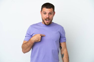 Genç Brezilyalı adam beyaz arka planda izole edilmiş, şaşırmış bir yüz ifadesi var.