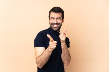 Kafkasyalı yakışıklı adam soyutlanmış arka planda ön tarafı gösteriyor ve gülümsüyor.