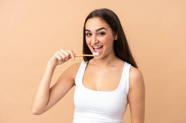 Bej arka planda diş fırçasıyla izole edilmiş beyaz bir kadın.