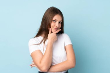 Genç beyaz kız mavi arka planda izole edilmiş mutlu ve gülümsüyor.