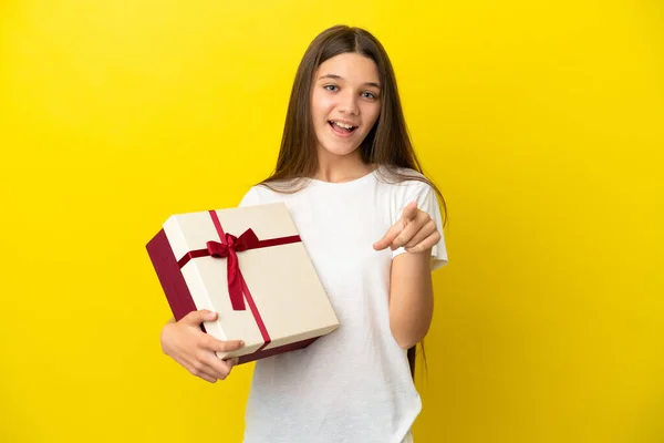 Niña Sosteniendo Regalo Sobre Fondo Amarillo Aislado Sorprendido Apuntando Hacia —  Fotos de Stock