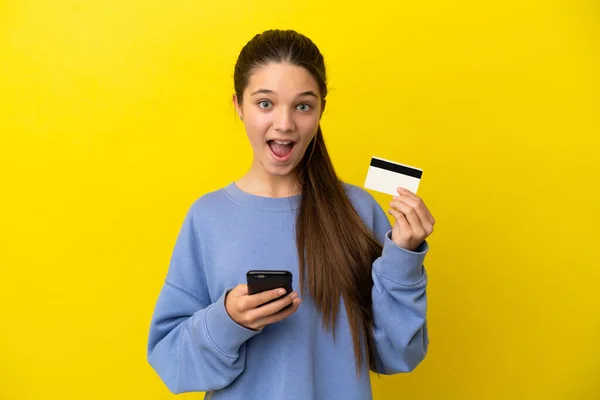 Klein Meisje Geïsoleerde Gele Achtergrond Kopen Met Mobiele Telefoon Het — Stockfoto