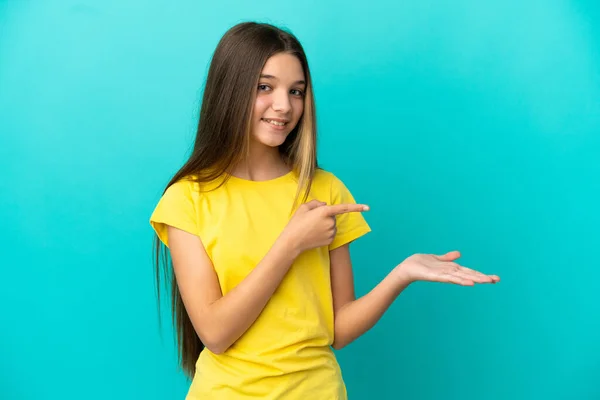 小さな女の子以上隔離された青の背景を保持コピースペース想像上の上に手のひらに挿入する広告 — ストック写真